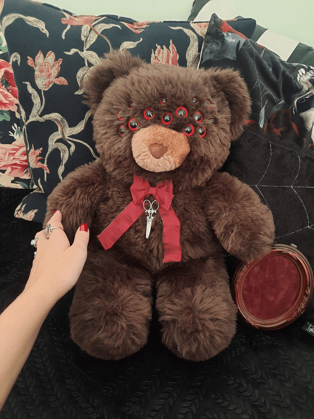 Peluche - ours aux yeux d'araignée rouges 